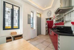 a kitchen with red cabinets and a clock on the wall at Mesquita in Silves