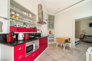 a kitchen with red cabinets and a dining room at Mesquita in Silves +4 photos