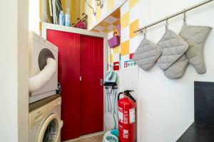 a laundry room with a red door and a washing machine at Mesquita in Silves