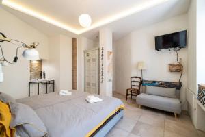 a bedroom with a bed and a chair and a tv at Mesquita in Silves