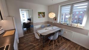 a dining room with a table and chairs in a room at Moderne Wohnung Cathy in Bad Iburg