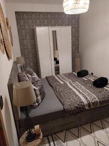 a bedroom with a bed with a lamp and a mirror at Beas Ferienglück in Busenberg