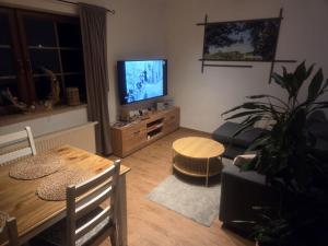 a living room with a table and a flat screen tv at Beas Ferienglück in Busenberg
