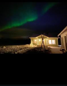 an image of the aurora in the sky over a house at Villa Kotikuja in Rovaniemi