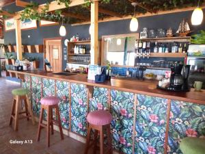 a bar with pink and green stools at Hooked on Panama Lodge in Limones