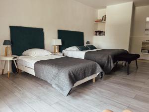 a bedroom with two beds and a table at La Petite maison de Céline & Frédéric avec piscine à Préhy in Préhy
