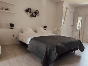 a bedroom with a bed and a clock on the wall at La Petite maison de Céline & Frédéric avec piscine à Préhy in Préhy