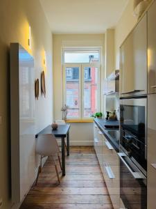 a kitchen with a table and a window in it at Appartement Premium à Liège in Liège