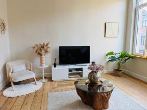 a living room with a flat screen tv and a table at Appartement Premium à Liège in Liège