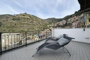 a chair on a balcony with a view of a mountain at Mare Mosso 1 in Manarola
