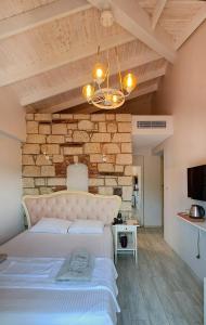 a bedroom with a large bed and a stone wall at Bellezza Hotel Alaçatı in Alaçatı