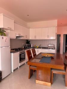 a kitchen with a wooden table and white appliances at Apartamento Rua do museu dos Náufragos in Sal Rei