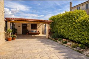 a patio of a house with a bench and a hedge at VILLA DEI CICAS in Taranto