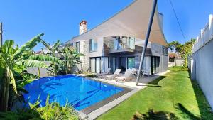 a house with a swimming pool in front of a house at Bellezza Hotel Alaçatı in Alaçatı