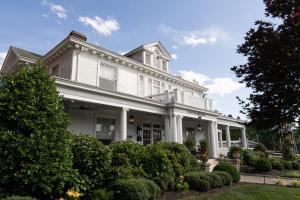 a white house with bushes in front of it at Pandora's Manor in High Point