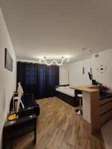 a living room with a desk and a bed at Apartament Golden Flight in Warsaw