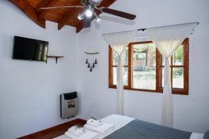 a bedroom with a bed and a ceiling fan at Complejo Falda del Sauce in Villa General Belgrano