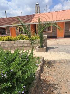 a building with an orange roof and some plants at Watene's Homes in Nairobi