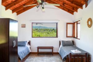 two beds in a room with a window at Complejo Falda del Sauce in Villa General Belgrano +95 photos