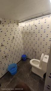 a bathroom with a toilet and a blue bidet at Kash Beach Villa, Varkala - Steps from Odayam Beach in Varkala