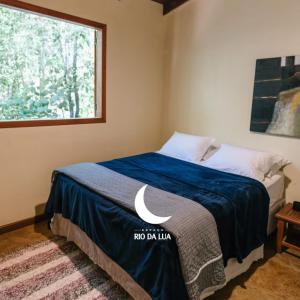 a bedroom with a bed with a blue blanket and a window at Casa do Cipó - Espaço Rio da Lua - São Jorge GO in Sao Jorge +61 photos