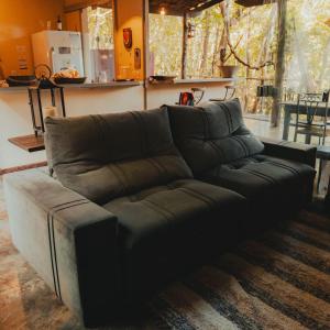 a brown couch in a living room at Casa do Cipó - Espaço Rio da Lua - São Jorge GO in Sao Jorge
