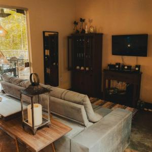 a living room with a couch and a television at Casa do Cipó - Espaço Rio da Lua - São Jorge GO in Sao Jorge