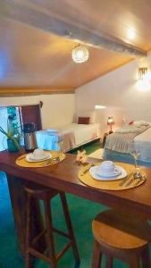 a room with a table with two beds and a bed at Pousada Lumawê Caraíva in Caraíva