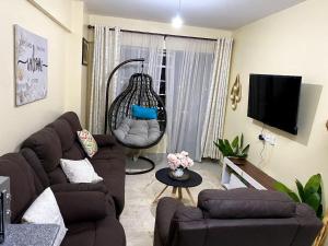 a living room with a couch and a tv at Casa Almasi in Nairobi