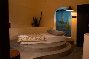 a bedroom with a bed sitting on a stone step at Kash Beach Villa, Varkala - Steps from Odayam Beach in Varkala