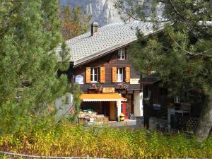 uma casa de madeira com árvores em frente em Pension Gimmelwald em Gimmelwald