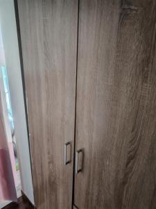 a wooden cabinet with two metal handles in a room at Vila Vera in Futog