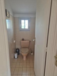 a bathroom with a toilet and a window at Chambre d'hôtes à Juvignac in Juvignac