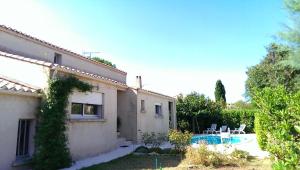 a house with a yard with a swimming pool at Chambre d'hôtes à Juvignac in Juvignac