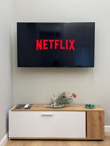 a tv on a wall with a netflix sign on it at TheCozy Home Tirana in Sauk +4 photos