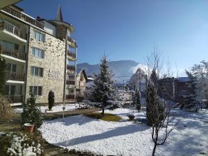 a building in the snow with trees in front of it at Sunny Studio Eagle Rock in Beli Iskar
