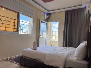 a bedroom with a large bed and a window at Residence Almahaj in Laayoune
