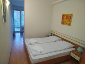 a small bedroom with a bed with white sheets at Sunny Studio Eagle Rock in Beli Iskar