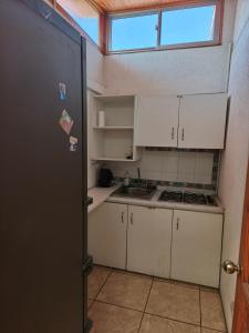 a small kitchen with white cabinets and a window at Casona Campillay in La Serena +8 photos