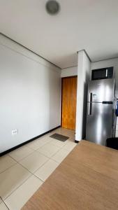 a kitchen with a stainless steel refrigerator in a room at Flat Premium no Centro Tudo a Pé in Montes Claros