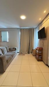 a living room with a couch and a flat screen tv at Flat Premium no Centro Tudo a Pé in Montes Claros +7 photos