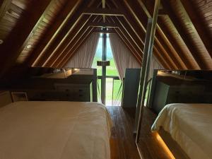 a room with two beds and a large window at Chalé Rústico com Piscina Aquecida e Hidro in Araranguá +14 photos