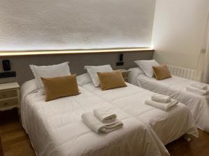 two beds in a room with towels on them at Hostal Restaurante Casa Santamaria in Doneztebe
