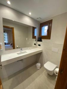 a bathroom with a sink and a toilet and a mirror at Hostal Restaurante Casa Santamaria in Doneztebe