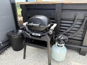a grill sitting on a stand next to a trash can at Ultimate Vineyard Escape - Waipara in Waipara