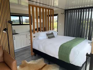 a bedroom with a large bed and a kitchen at Ultimate Vineyard Escape - Waipara in Waipara
