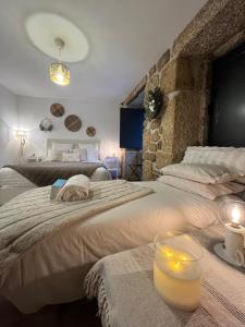 a bedroom with two beds and a candle on a table at Senhora da Estrela AL in Seia +39 photos