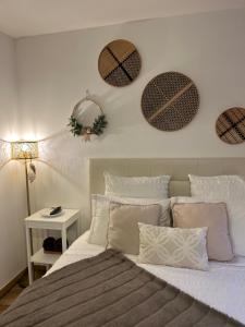 a bedroom with a bed with four wreaths on the wall at Senhora da Estrela AL in Seia