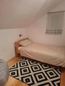 a bedroom with two beds and a rug at Nature escape Sarajevo in Kasatići