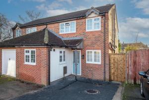 a red brick house with a white garage at 4 Bedroom Family & Contractor House in Colwick, Nottingham - Sleeps 8 - By CircleWay Homes in Nottingham
